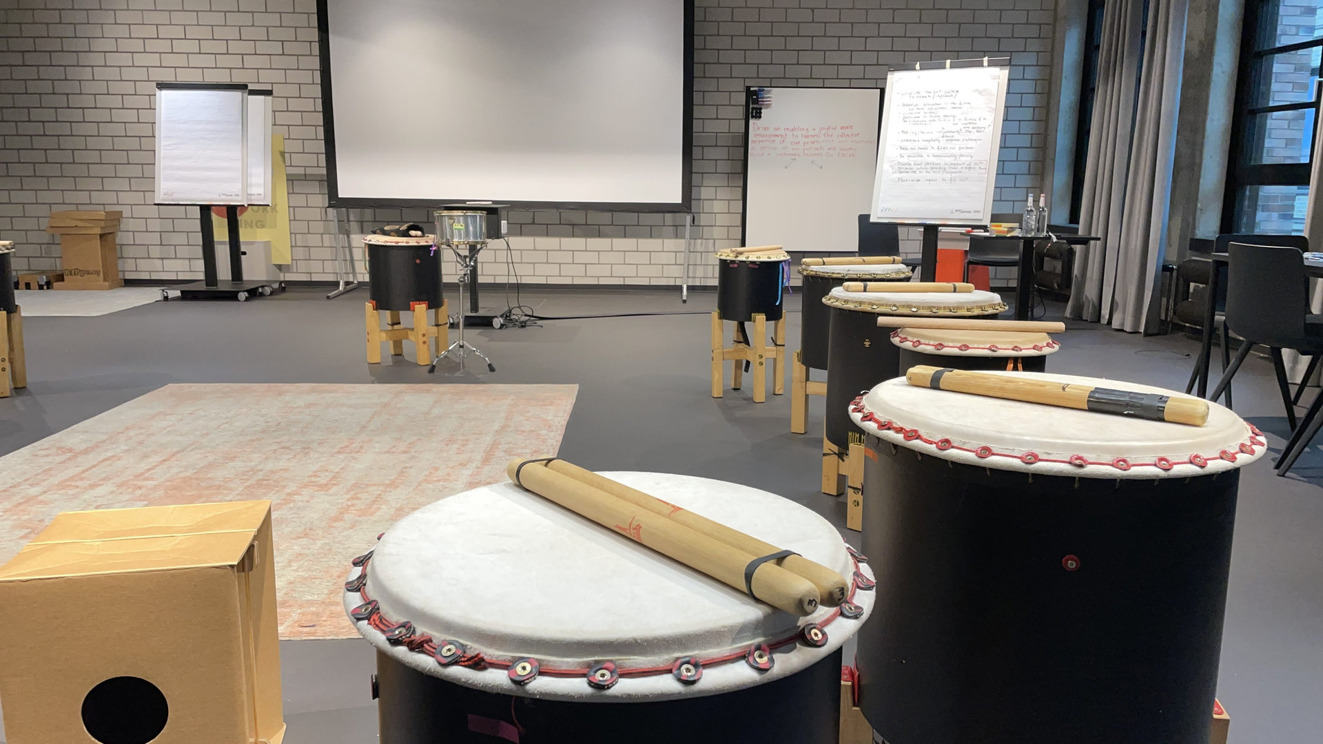Taiko-Trommeln und Flipcharts stehen bereit in einem Workshop-Raum